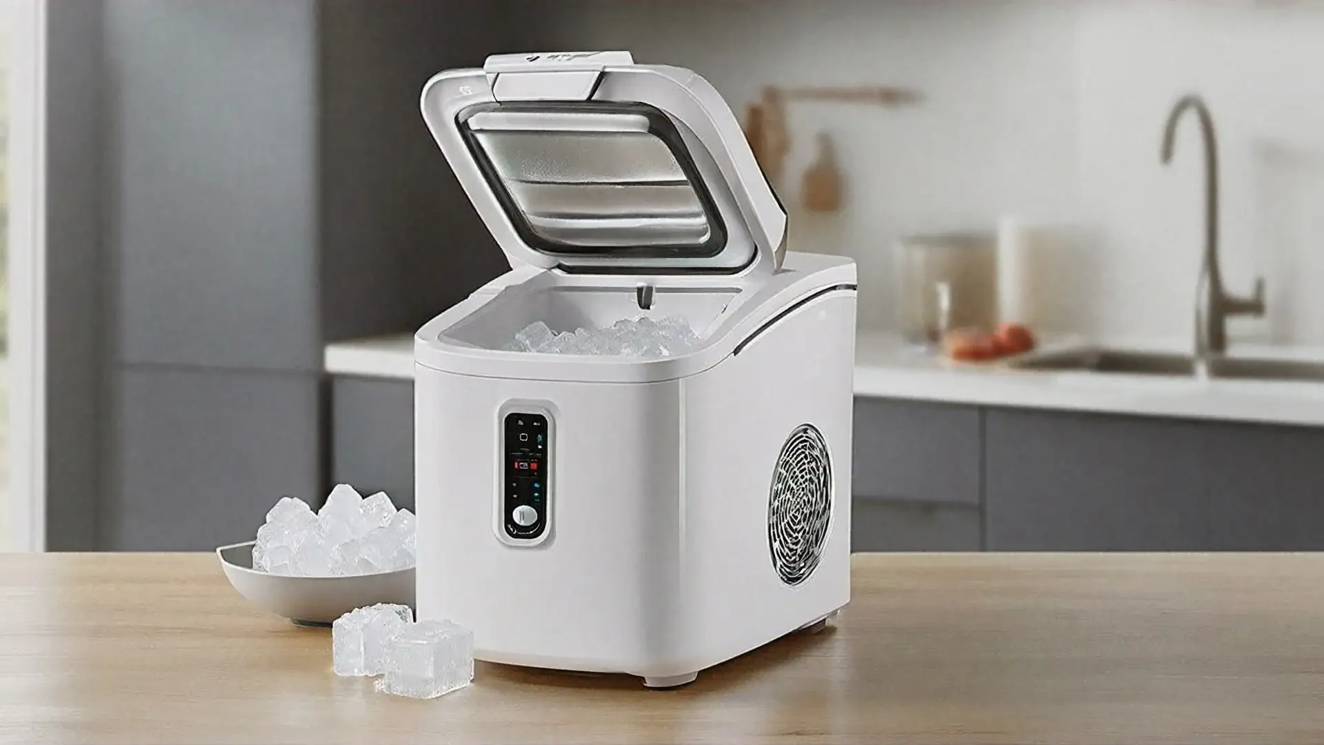 Modern countertop ice maker with open lid showing ice cubes inside, positioned on wooden kitchen counter with bowl of ice nearby