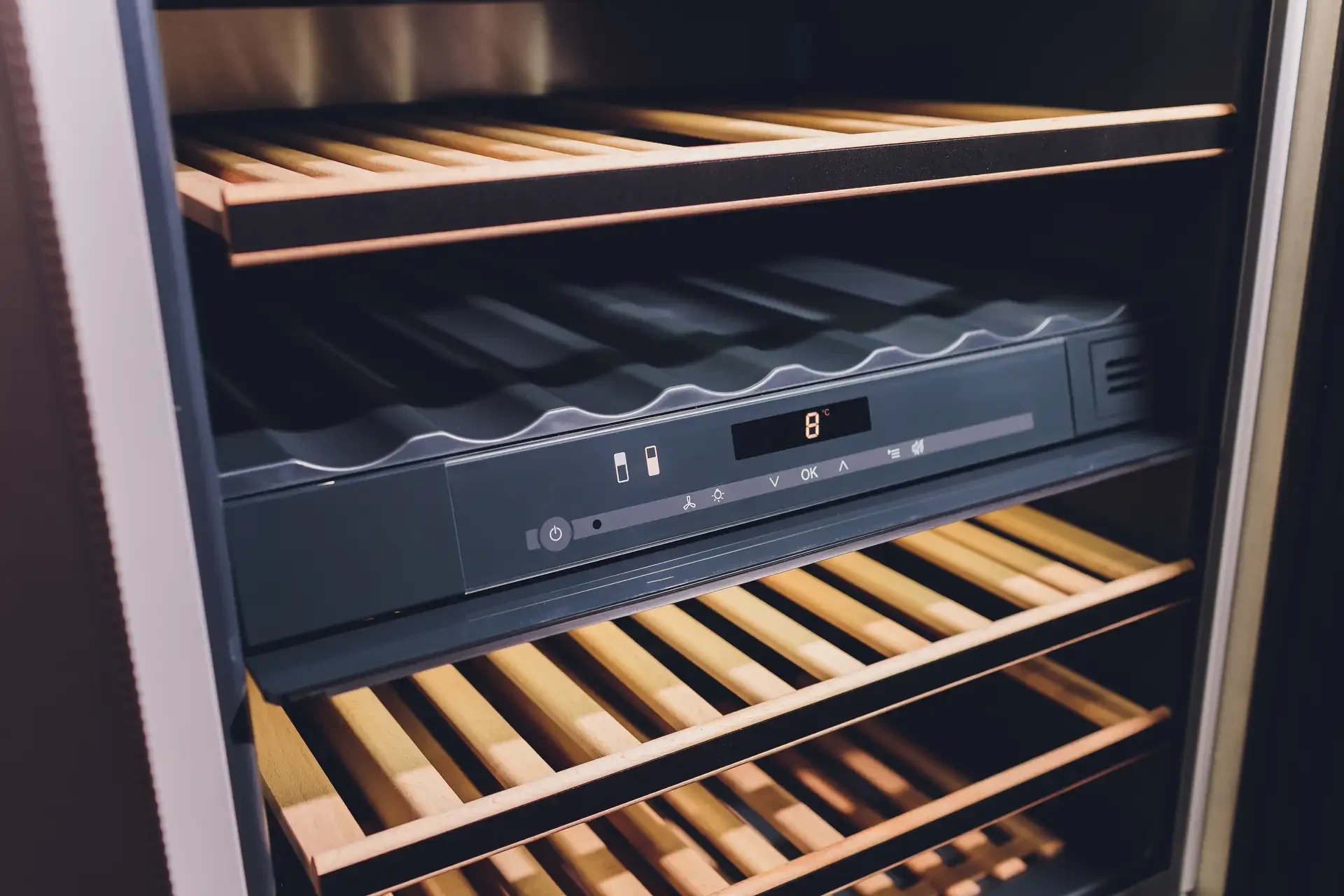 Wine refrigerator interior showing wooden shelves for bottle storage and digital temperature display reading 8°C